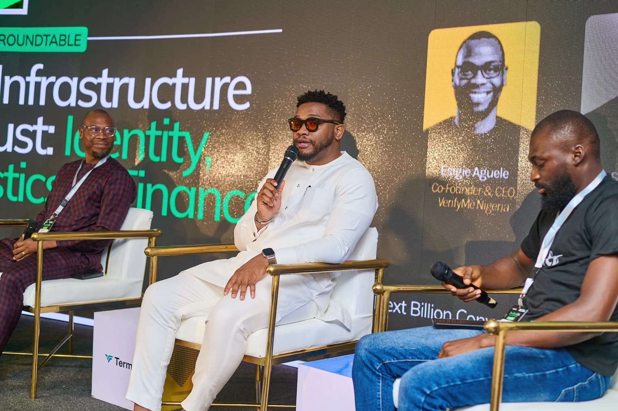 Three panellists in conversation on stage during a roundtable